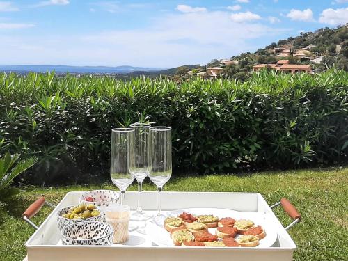 - une table avec deux verres à vin et une assiette de nourriture dans l'établissement Villa Verde climatisée pour 10 personnes avec piscine chauffée et vue mer à La Londe les Maures, à La Londe-les-Maures