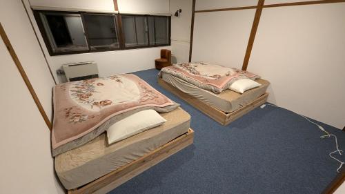 two twin beds in a room with at オーベルジュ樹氷 in Yamagata