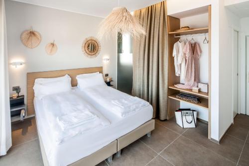 a bedroom with a large white bed and a closet at Hotel Moresco in Diano Marina