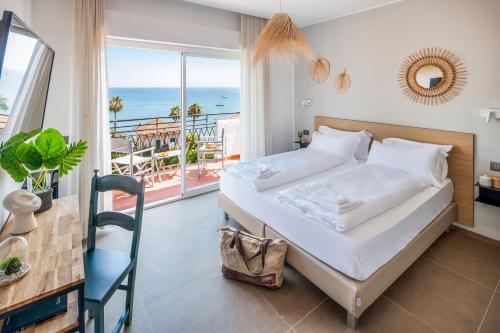 a bedroom with a bed and a view of the ocean at Hotel Moresco in Diano Marina