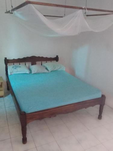 a bedroom with a wooden bed with a blue mattress at Appartement F2 50m2 centre ville sécurisé in Diego Suarez