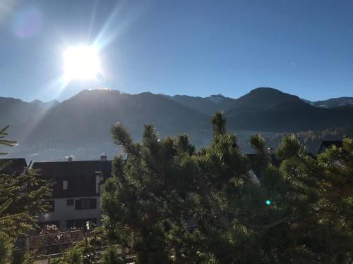 a view of a mountain with the sun in the sky at Suite Marco nice apartment in Cavalese with View in Cavalese