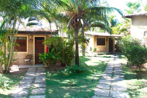 a house with a palm tree in the yard at Pousada Império do Sol in Pipa
