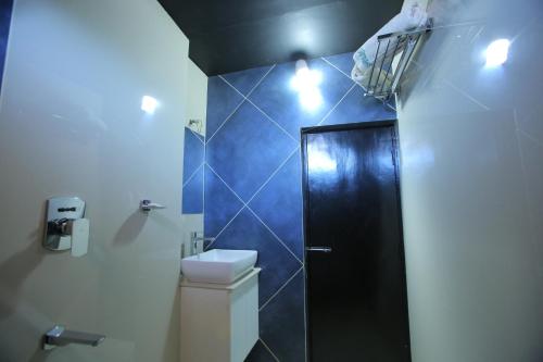 a bathroom with a toilet and a black shower at City Palace Hotel in Ooty
