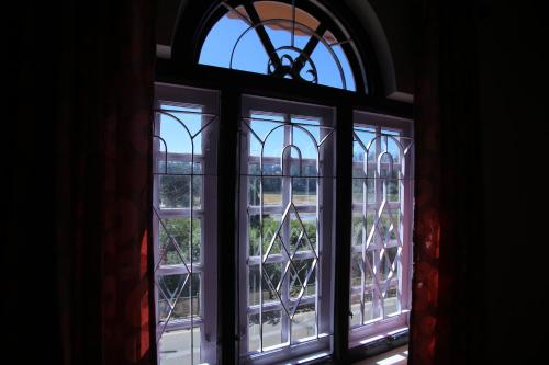 an open window with a view of a building at City Palace Hotel in Ooty