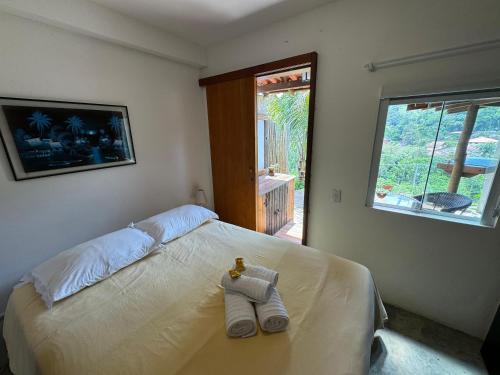 ルミアルにあるSerena Suíte Lumiarのタオルが敷かれたベッドのある寝室