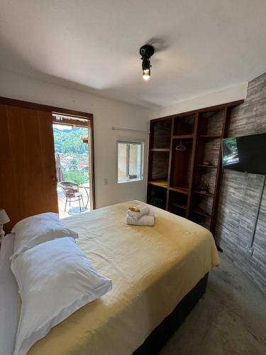 a bedroom with a large bed with two towels on it at Serena Suíte Lumiar in Lumiar
