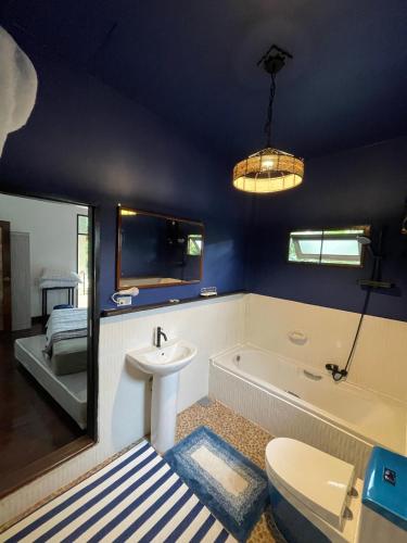 a bathroom with a tub and a sink and a toilet at Villa Aisawan in Phuket