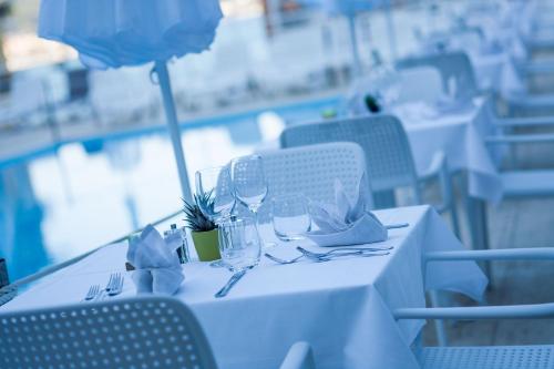 a white table with glasses and napkins on it at Hotel Moresco in Diano Marina