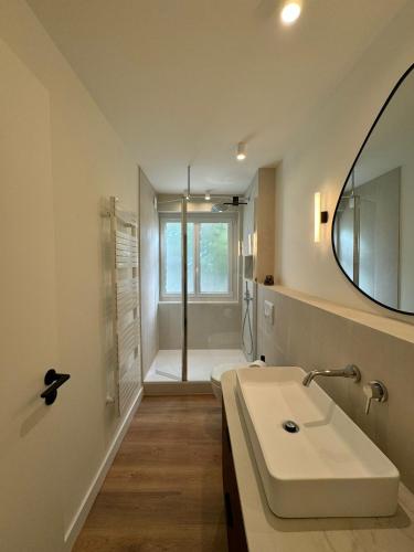 une salle de bain avec un lavabo et une douche avec un miroir dans l'établissement Villa NAIO - Piscine privée - Parking - Climatisation, à Cassis