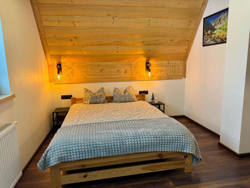 Un dormitorio con una cama con techo de madera. en Koperkowe Domki Zakopane, en Zakopane