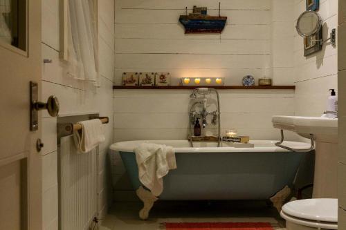 a bathroom with a bath tub and a sink at Beachfront House w Pool & Steam in West Wittering
