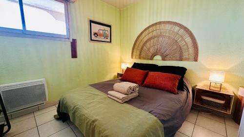 une chambre avec un lit avec des oreillers rouges et une fenêtre dans l'établissement Horizon Nostrum YourHostHelper, à Palavas-les-Flots