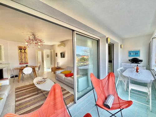 un salon avec des chaises rouges et une table dans l'établissement Appartement vue sur les toits de Propriano, à Propriano