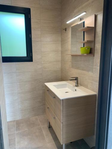 une salle de bain avec un lavabo blanc et une fenêtre dans l'établissement Villa SOLEIL, à Figari