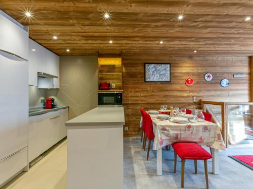 une cuisine et une salle à manger avec une table et des chaises rouges dans l'établissement Spacieux duplex 3P avec wifi et balcon sud, parking inclus, près des pistes à Val-d'Isère - FR-1-694-27, à Val dʼIsère