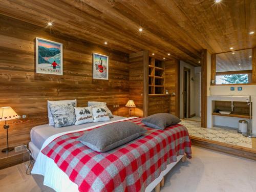 une chambre avec un lit dans une pièce aux murs en bois dans l'établissement Spacieux duplex 3P avec wifi et balcon sud, parking inclus, près des pistes à Val-d'Isère - FR-1-694-27, à Val dʼIsère