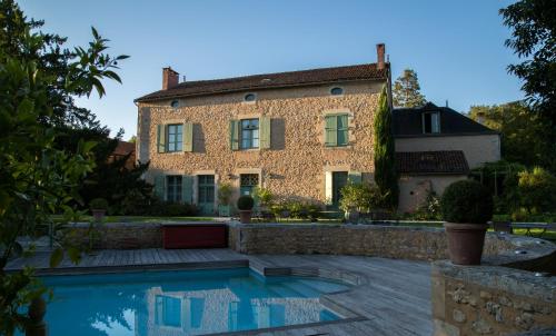 une grande maison avec une piscine en face de celle-ci dans l'établissement Hôtel Les Orangeries, à Lussac-les-Châteaux