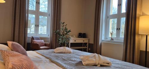 a bedroom with two towels on a bed with windows at Schlosshotel Hohenbocka in Hohenbocka