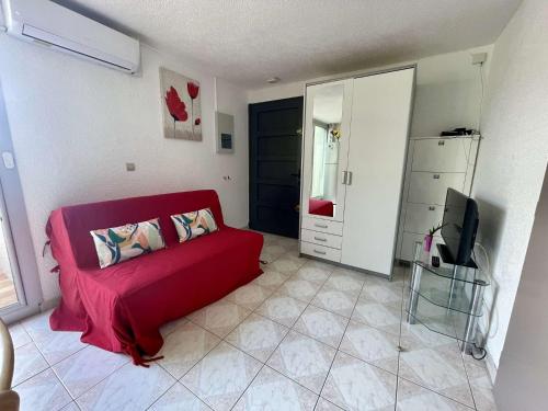 un salon avec un canapé rouge et une télévision dans l'établissement Appartement 2 pièces 4 couchages ST CYPRIEN PLAGE SC510-172I, à Saint Cyprien Plage