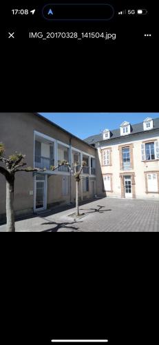 une photo d'un bâtiment avec un arbre devant lui dans l'établissement Studio Gare SNCF, à Tarbes