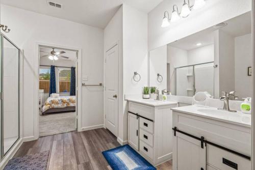 a white bathroom with two sinks and a mirror at Crew Stay Sleeps 10, Wi-fi, Parking, Big Backyard in Lavon