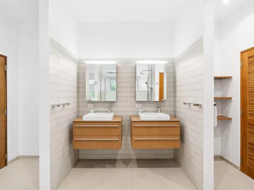 a bathroom with two sinks and two mirrors at This place was great to accommodate everyone in Koolbaai