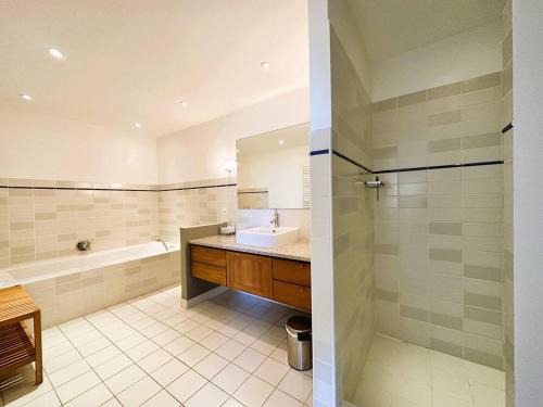 une salle de bain avec une baignoire, un lavabo et une douche dans l'établissement Villa Les Romarins pour 8 personnes avec vue mer panoramique et piscine chauffée à La Londe-les-Maures, à La Londe-les-Maures