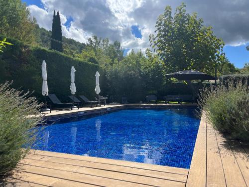 une piscine avec des chaises et un parasol dans l'établissement Domaine Azad Auriol, à Auriol