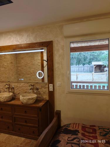 une salle de bain avec deux lavabos et une fenêtre dans l'établissement Appartement insolite au Ranch Wamakiti, à Le Soler