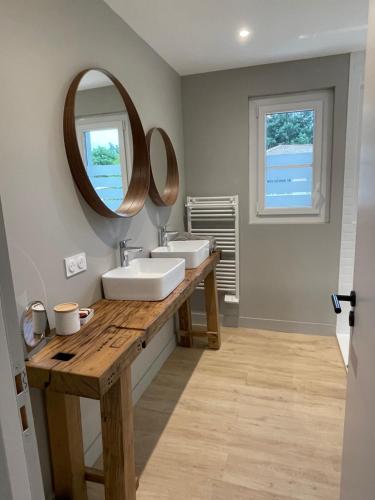 une salle de bain avec deux lavabos et un miroir dans l'établissement Villa Lucio, à Parentis-en-Born