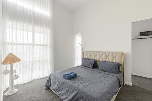 a bedroom with a bed with a blue towel on it at Modern villa near the beach 12 sleep in Ocean Grove