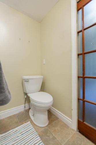a bathroom with a white toilet in a room at Barrie Bliss 3BR Haven near Centennial Beach in Barrie