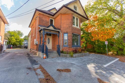 a brick house on a street with a driveway at Barrie Bliss 3BR Haven near Centennial Beach in Barrie