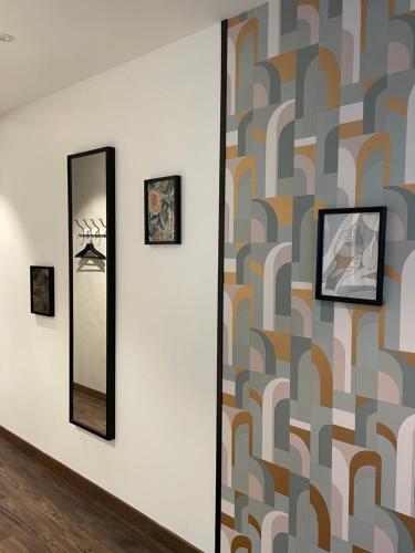 a wall with three mirrors and a wall with pictures at Les Cépages in Le Mesnil-sur-Oger