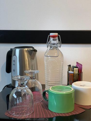 a counter with two glass containers and a bottle of water at Les Cépages in Le Mesnil-sur-Oger
