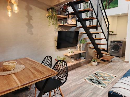 a living room with a table and chairs and a staircase at Hope Aparta Lofts in Salento