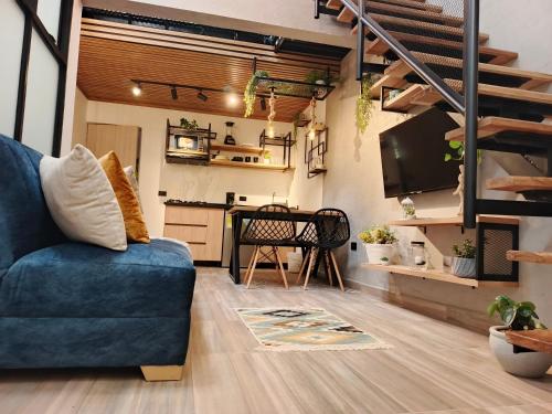 a living room with a blue couch and a kitchen at Hope Aparta Lofts in Salento