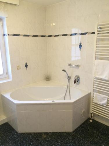 a bath tub with a faucet in a bathroom at Schloss Hotel Holzrichter in Nachrodt-Wiblingwerde