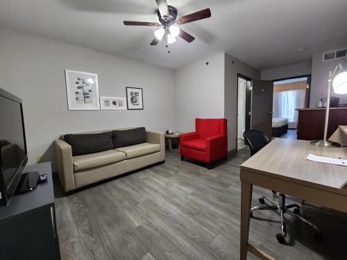 a living room with a couch and a red chair at Country Inn & Suites by Radisson, Topeka West, KS in Topeka