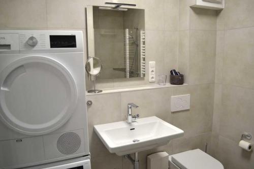 a bathroom with a sink and a toilet and a mirror at 4 Sterne Wohnung Orchidee in Brüggen