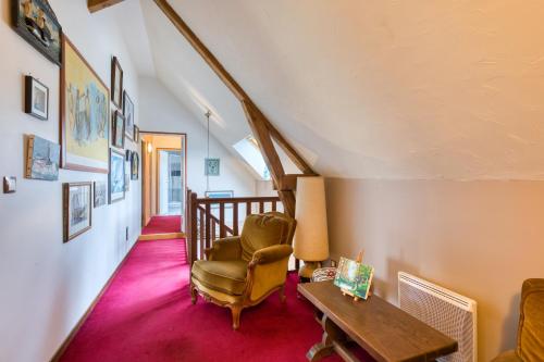 un salon avec une chaise et une table dans l'établissement Maison de vacances and B&B clos des hogues entre Etretat et Fécamp, à Saint-Léonard