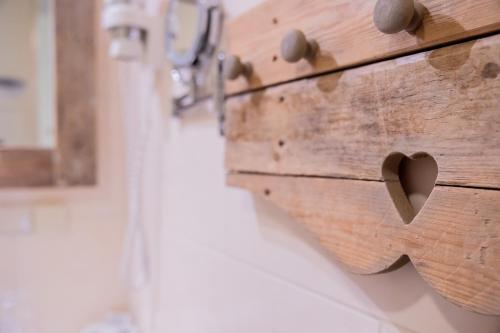 a wooden chest with hearts on the wall at Hotel De Walvisvaarder in Lies