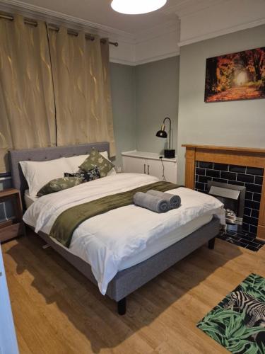 a bedroom with a large bed and a fireplace at The Reddish Retreat in Manchester