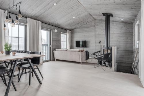 a living room with a table and chairs and a couch at Bastuvallen - Ramundberget in Bruksvallarna