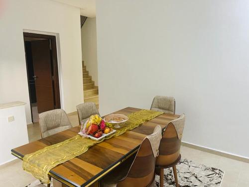 una mesa de comedor con un bol de fruta. en villa azur, en Dar Bouazza