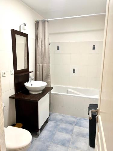 une salle de bain avec un lavabo, une baignoire et des toilettes dans l'établissement Appartement calme avec exterieur, à Aytré