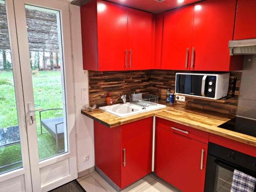 - une cuisine rouge avec évier et four micro-ondes dans l'établissement 02 - Très joli 2 pièces avec 3 lits pouvant accueillir jusqu'à 5 personnes, situé au rdc avec entrée indépendante, une place de parking réservée devant l'entrée et terrasse sur l'arrière donnant sur parc arboré, tout le linge de maison est fourni, à Razac-sur-lʼIsle