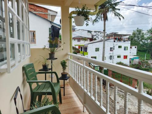 a balcony with chairs and a table and a view of buildings at Hope Aparta Lofts in Salento