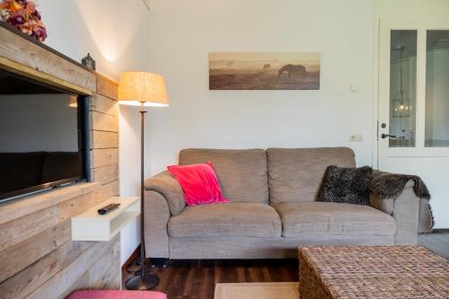 a living room with a couch and a flat screen tv at Hotel De Walvisvaarder in Lies
